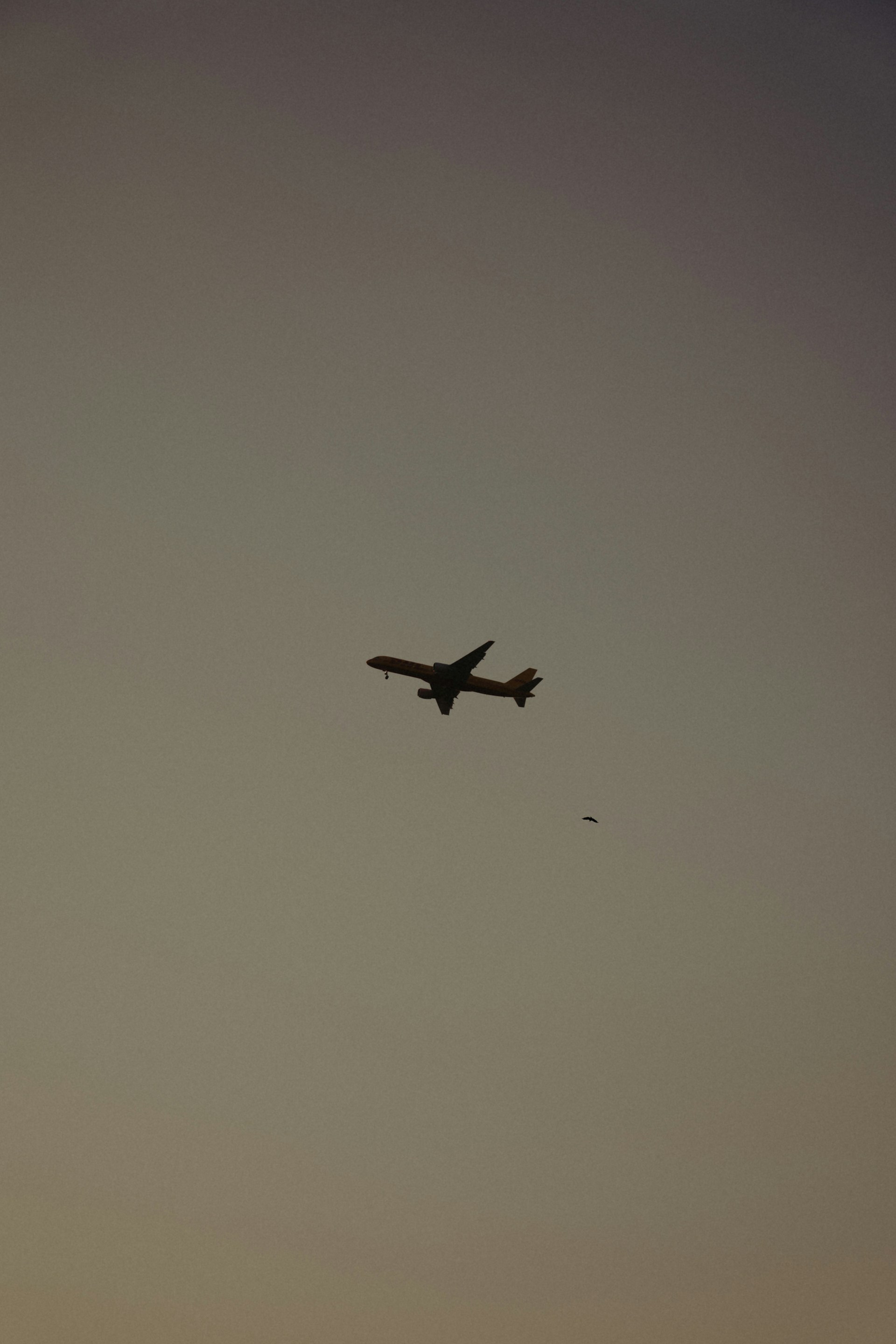 an airplane is flying in the sky at sunset