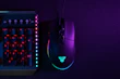 RGB gaming keyboard and mouse glowing vibrantly in a dark room.