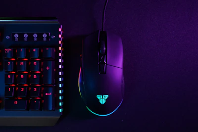 A sleek gaming setup with glowing neon purple lights illuminating a keyboard and mouse.
