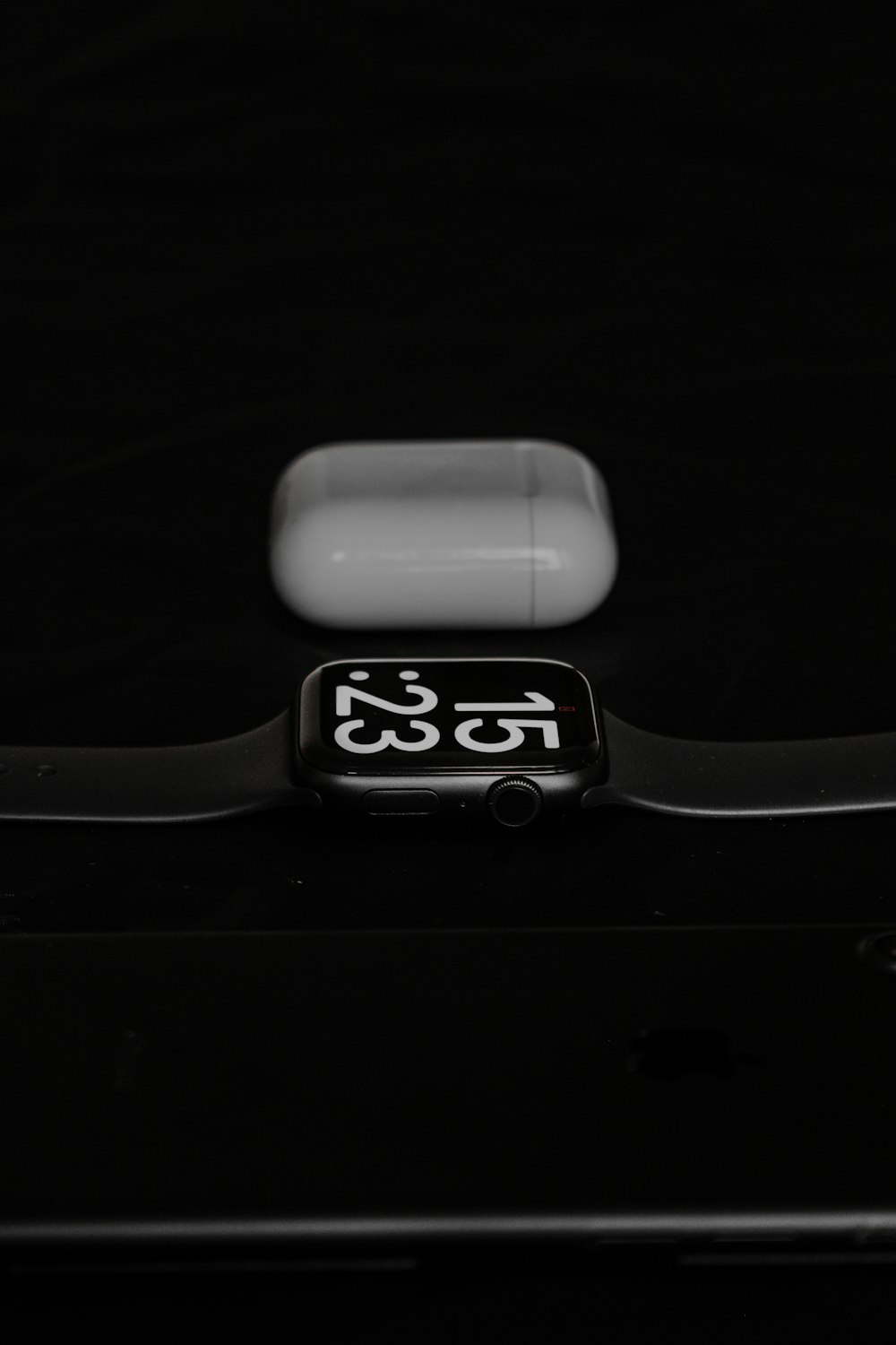 an apple watch sitting on top of a black surface