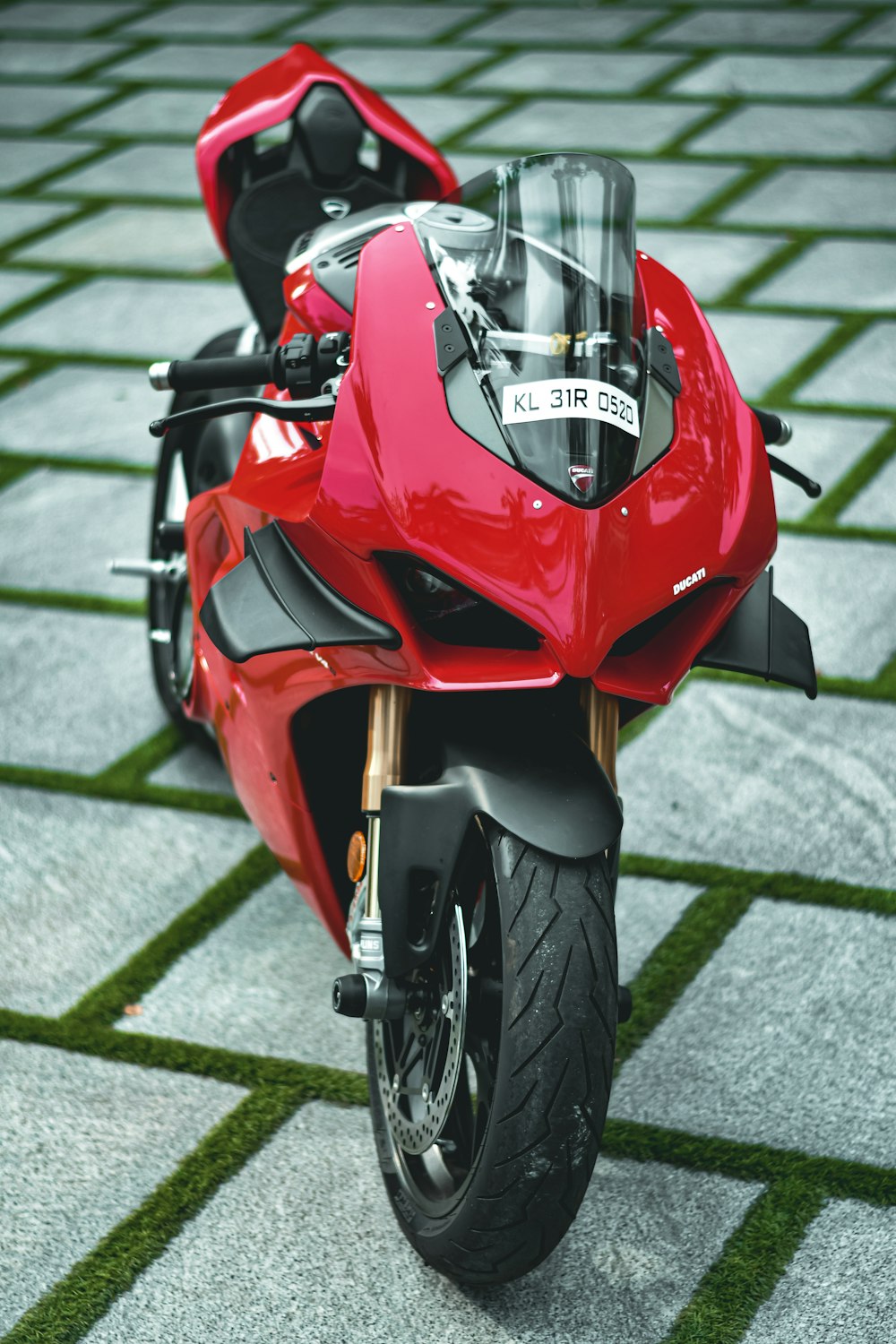 a red motorcycle parked on top of a tiled floor