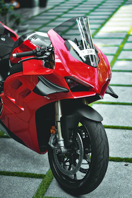A sleek red sport motorcycle parked on a winding mountain road at sunset.