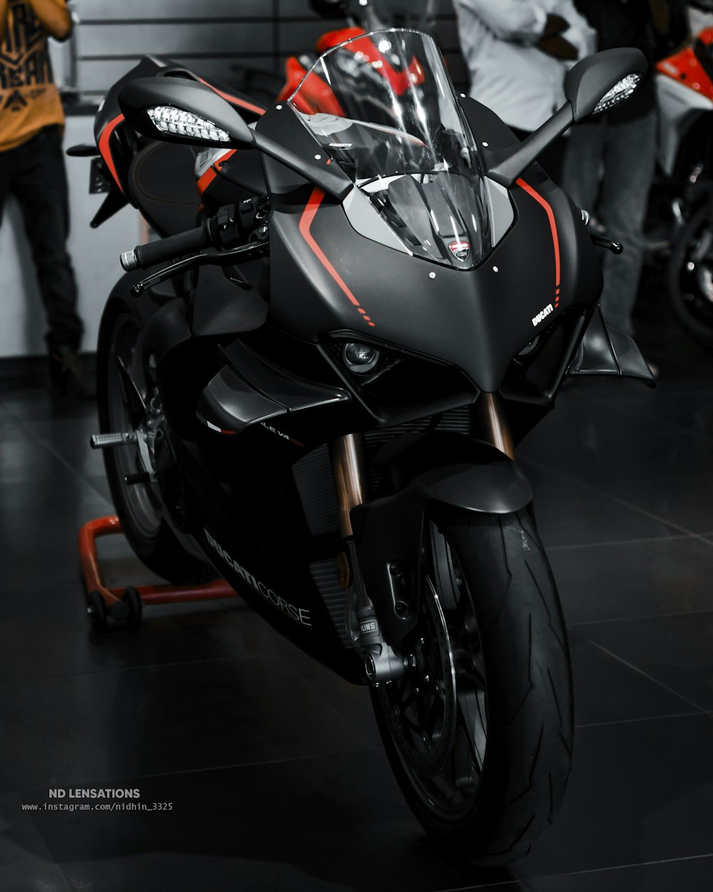 a black and red motorcycle on display at a show