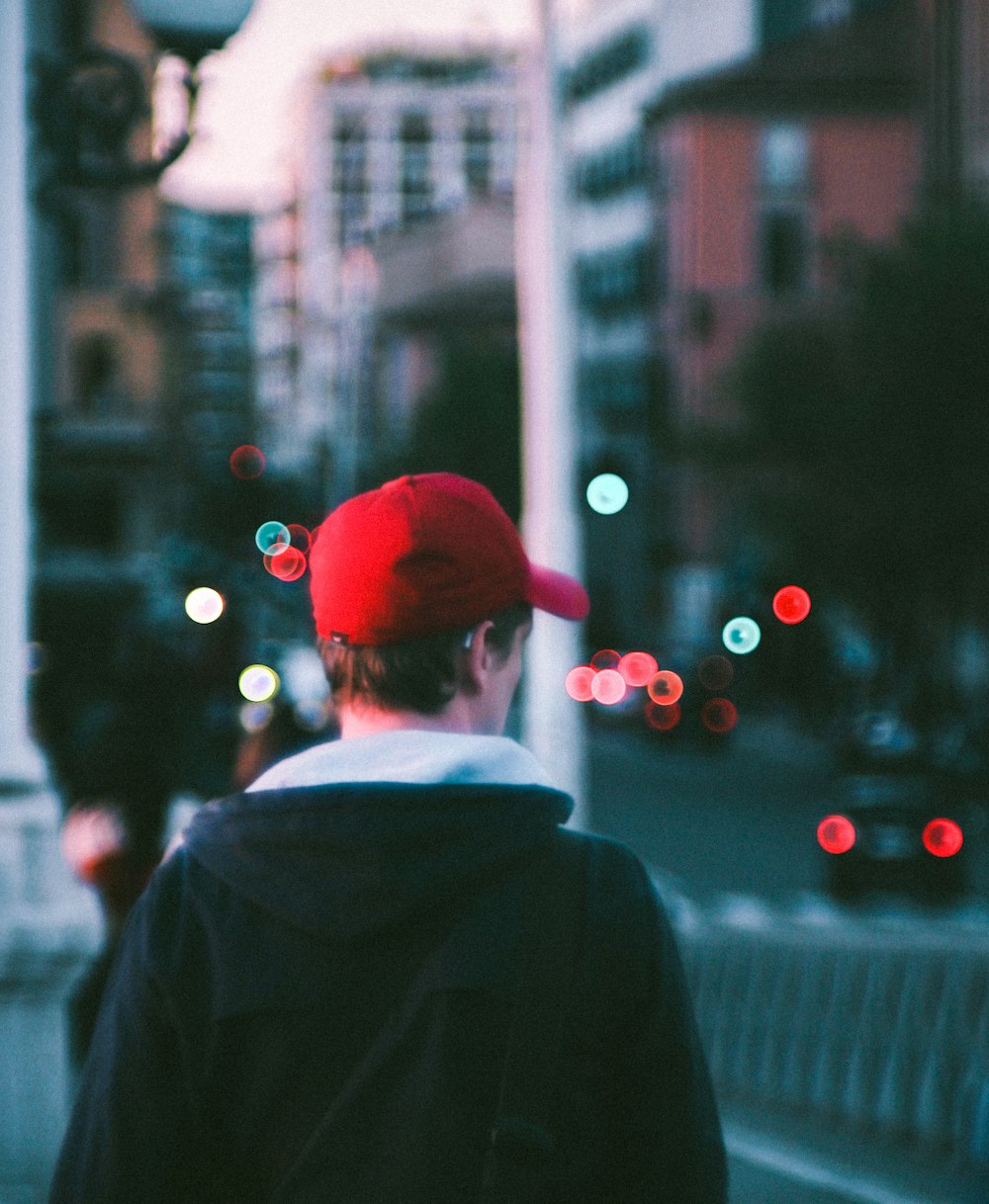 a man in a red hat is walking down the street