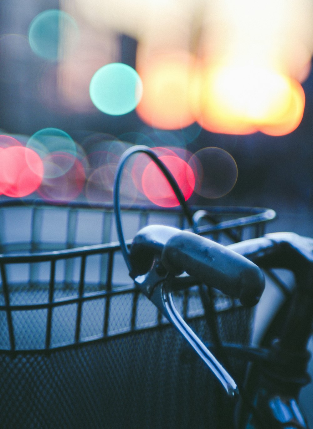 a close up of a bicycle handlebar with blurry lights in the background