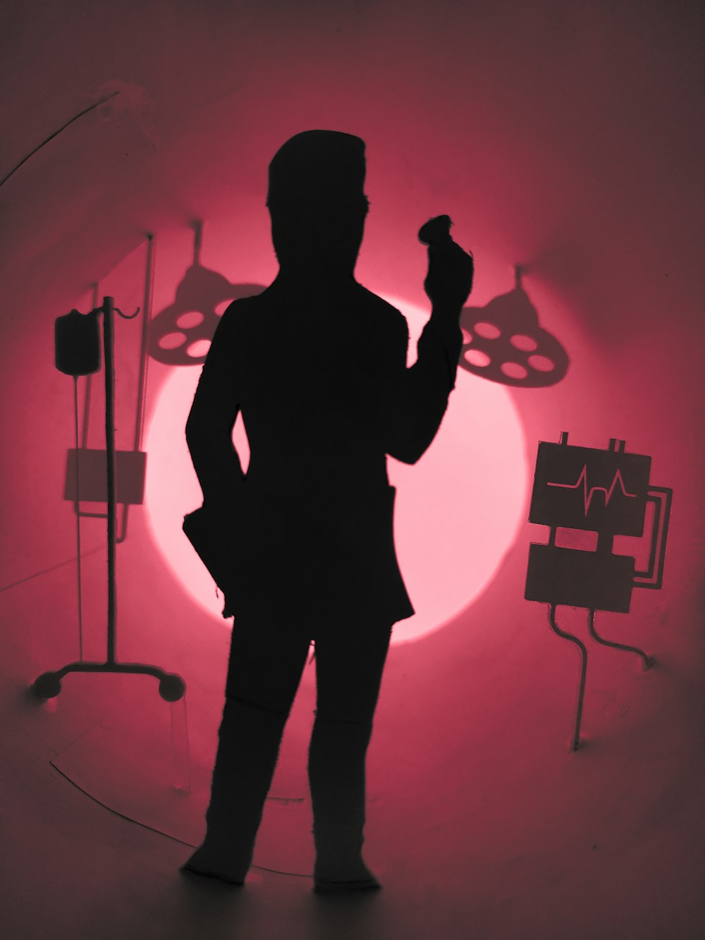 a silhouette of a person standing in front of a red light