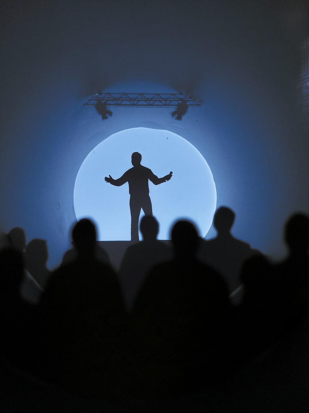 a silhouette of a man standing in front of a crowd
