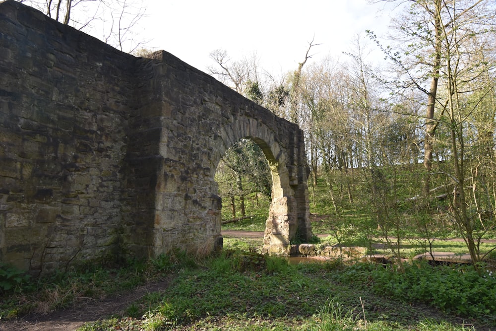 an old stone bridge in a wooded area
