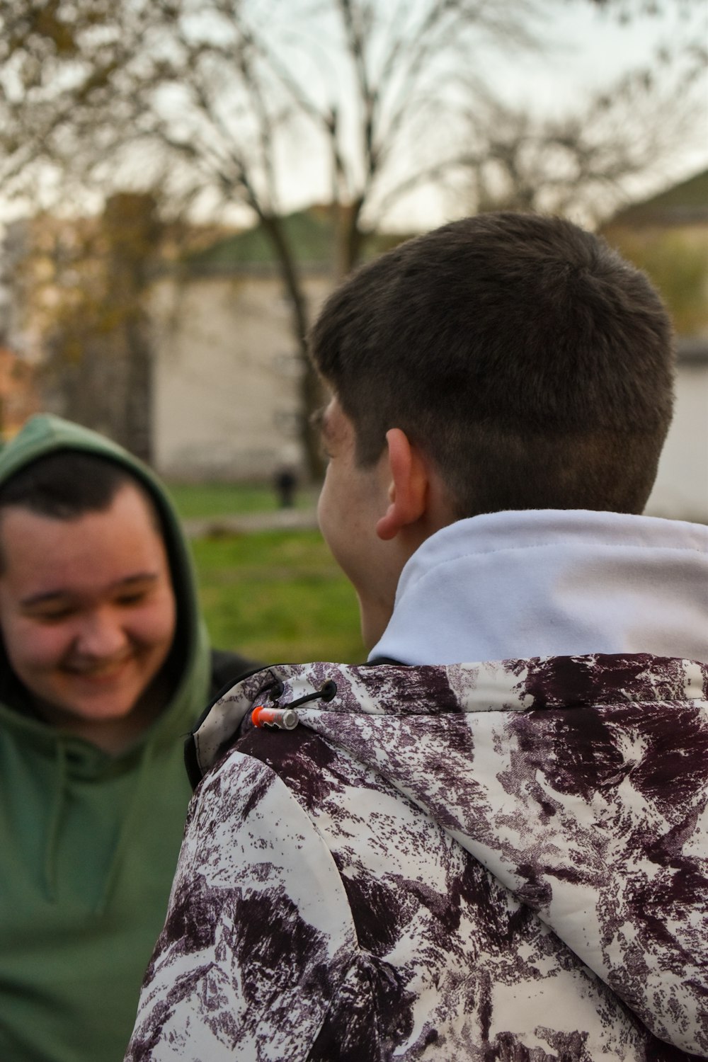 a man in a green hoodie and a man in a black and white jacket