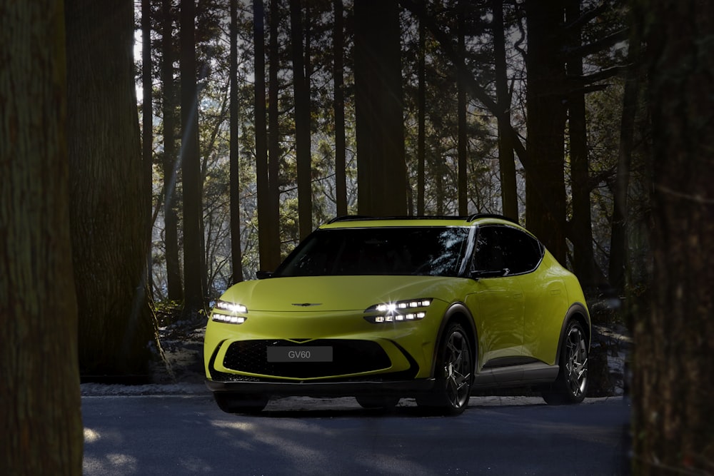 a yellow sports car driving through a forest