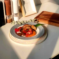 A close-up of a lunch plate with a variety of delicious food, accompanied by a glass and cutlery.