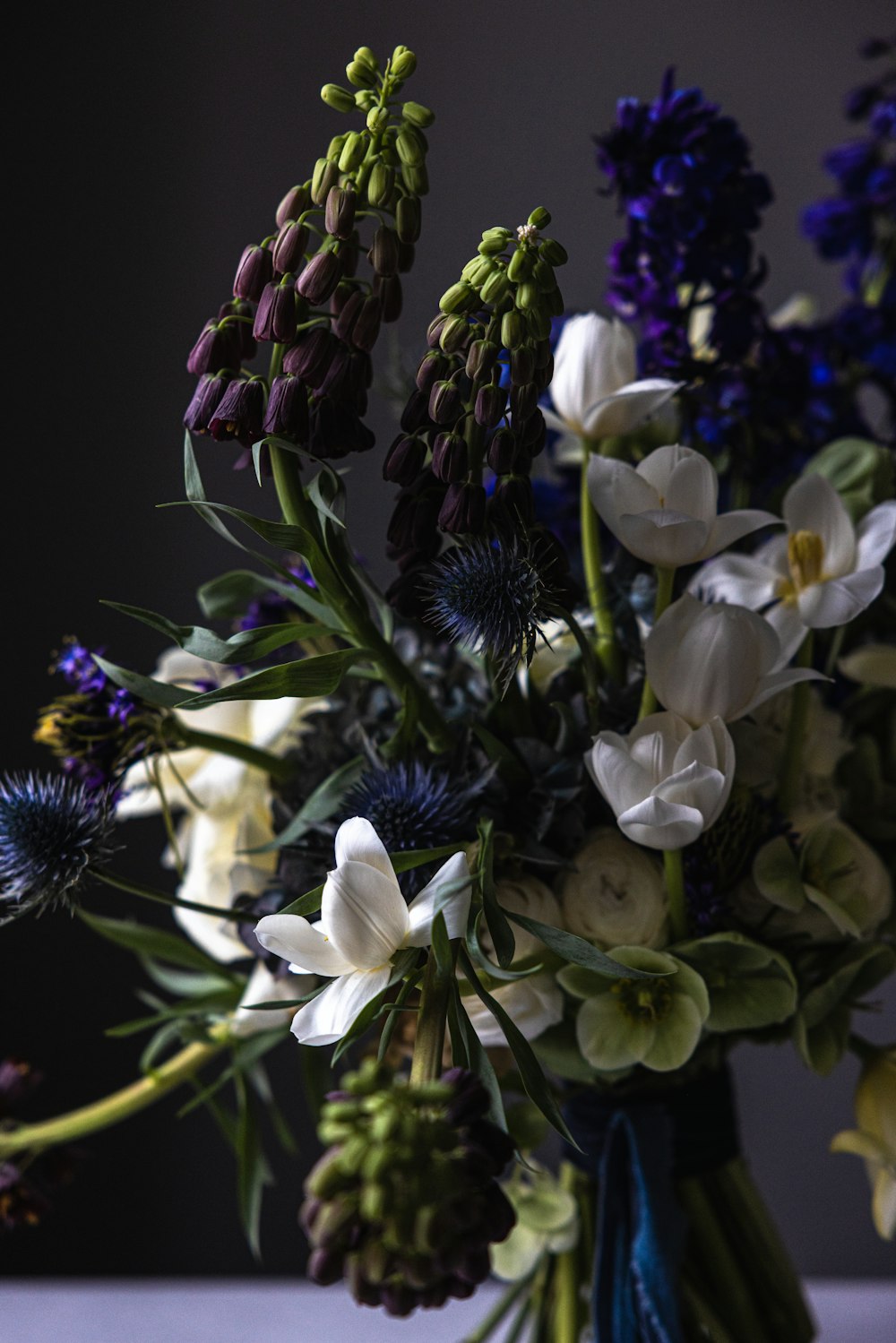 a vase filled with lots of flowers on top of a table