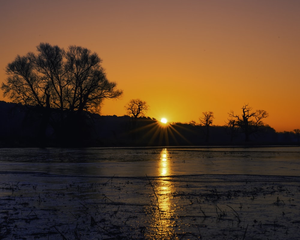 the sun is setting over a body of water