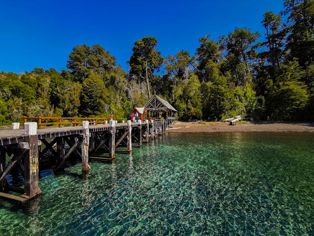 a wooden pier with a small hut on top of it