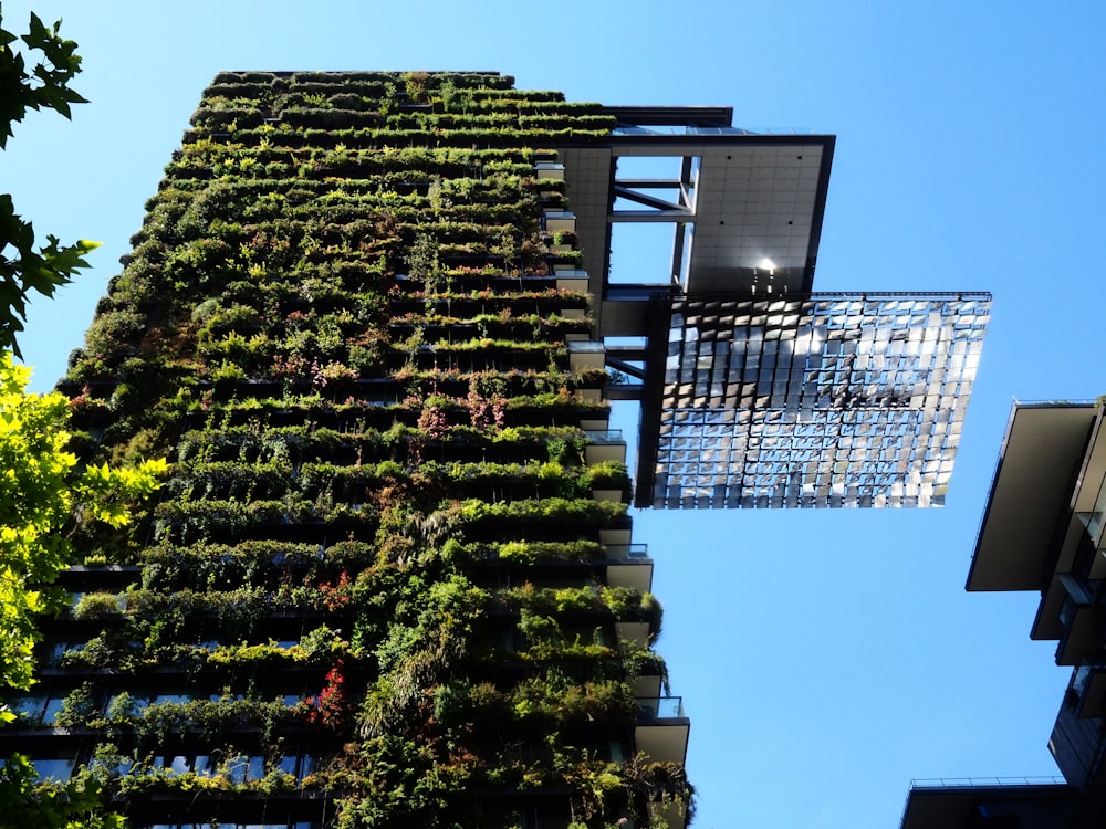 a very tall building with a bunch of plants growing on it