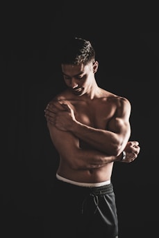 a shirtless man with his arms crossed