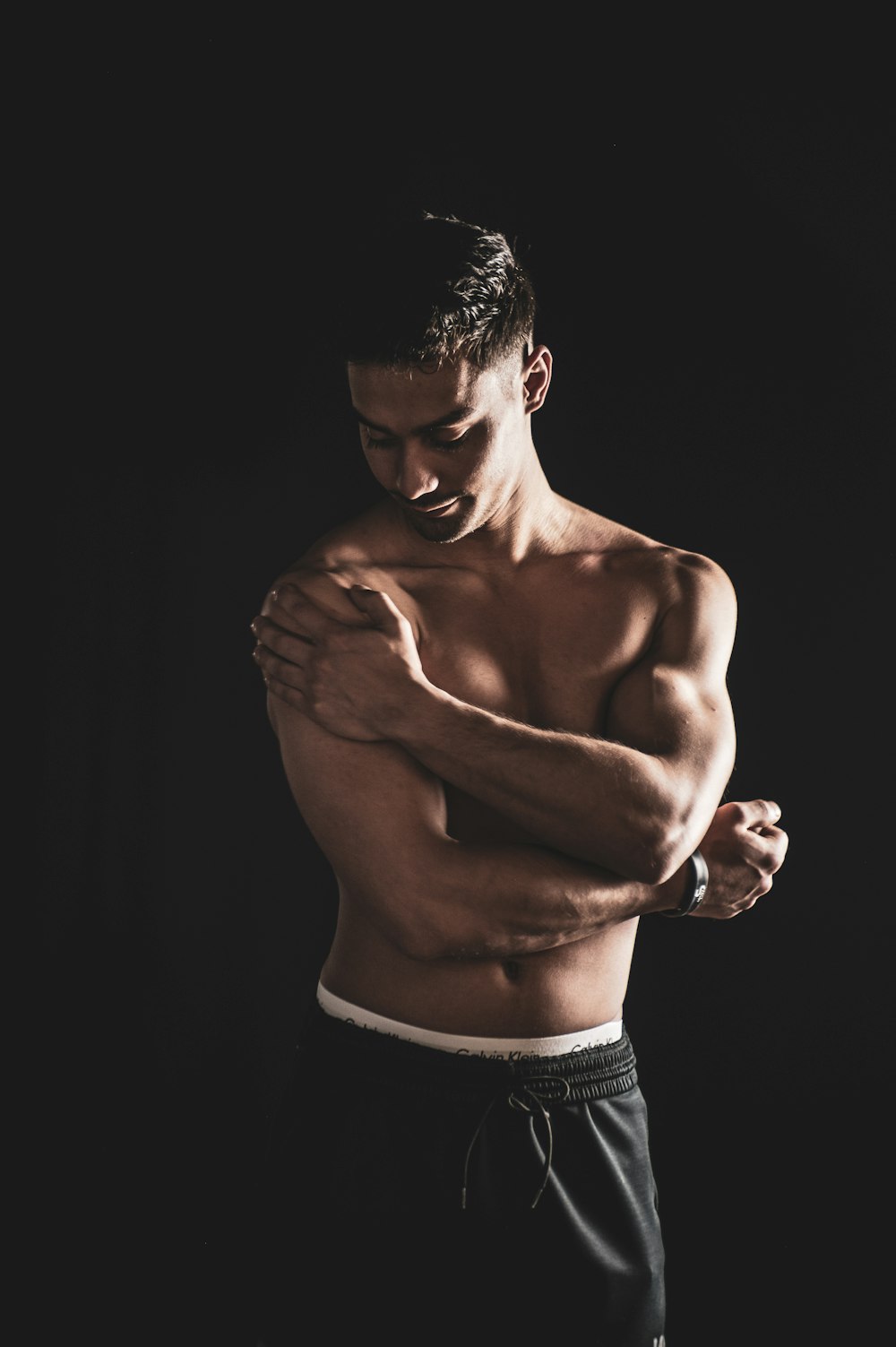 a shirtless man with his arms crossed