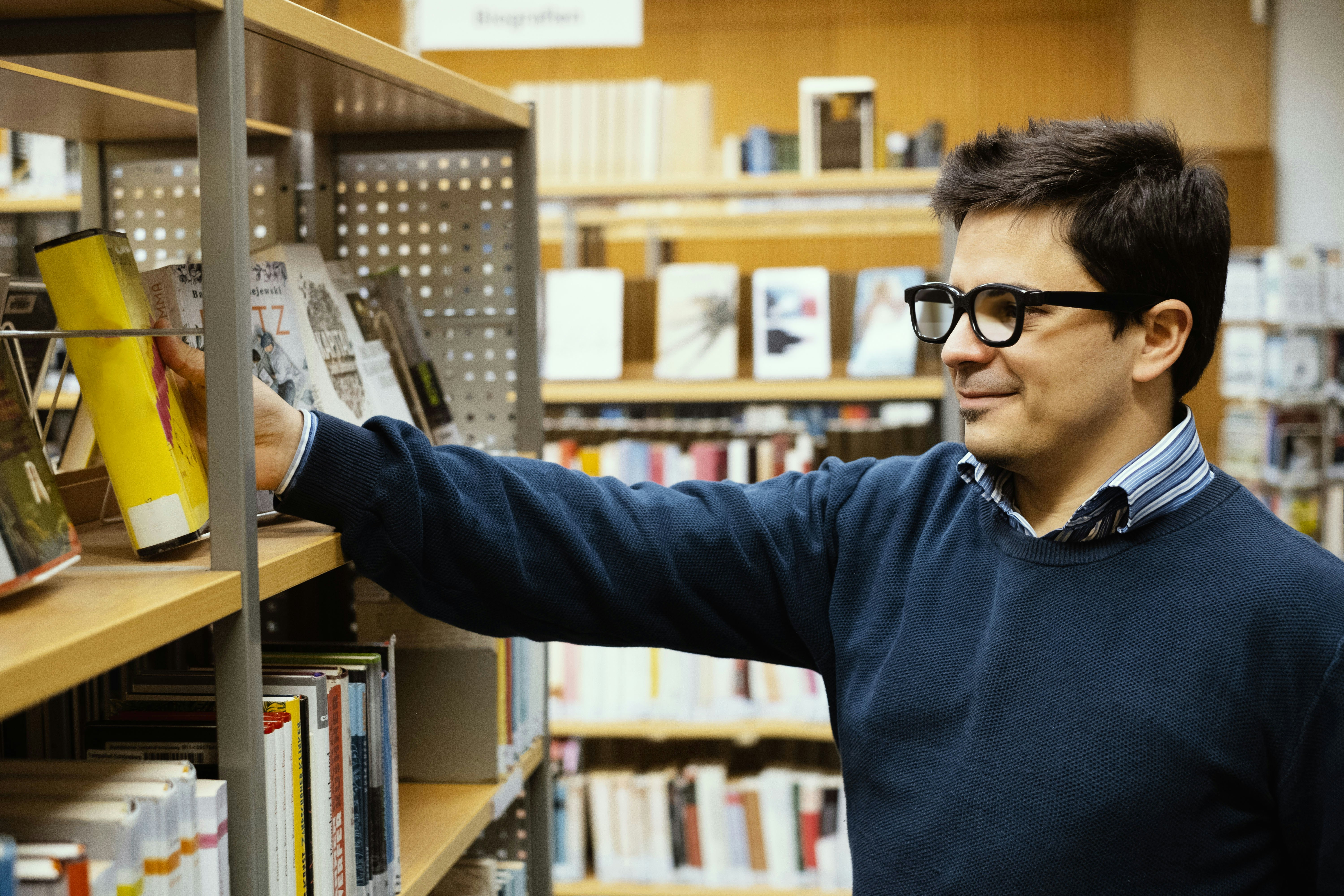 a man in a library looking at a book