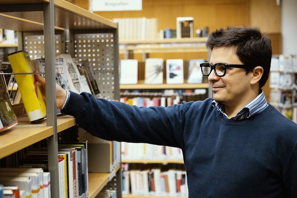 a man in a library looking at a book