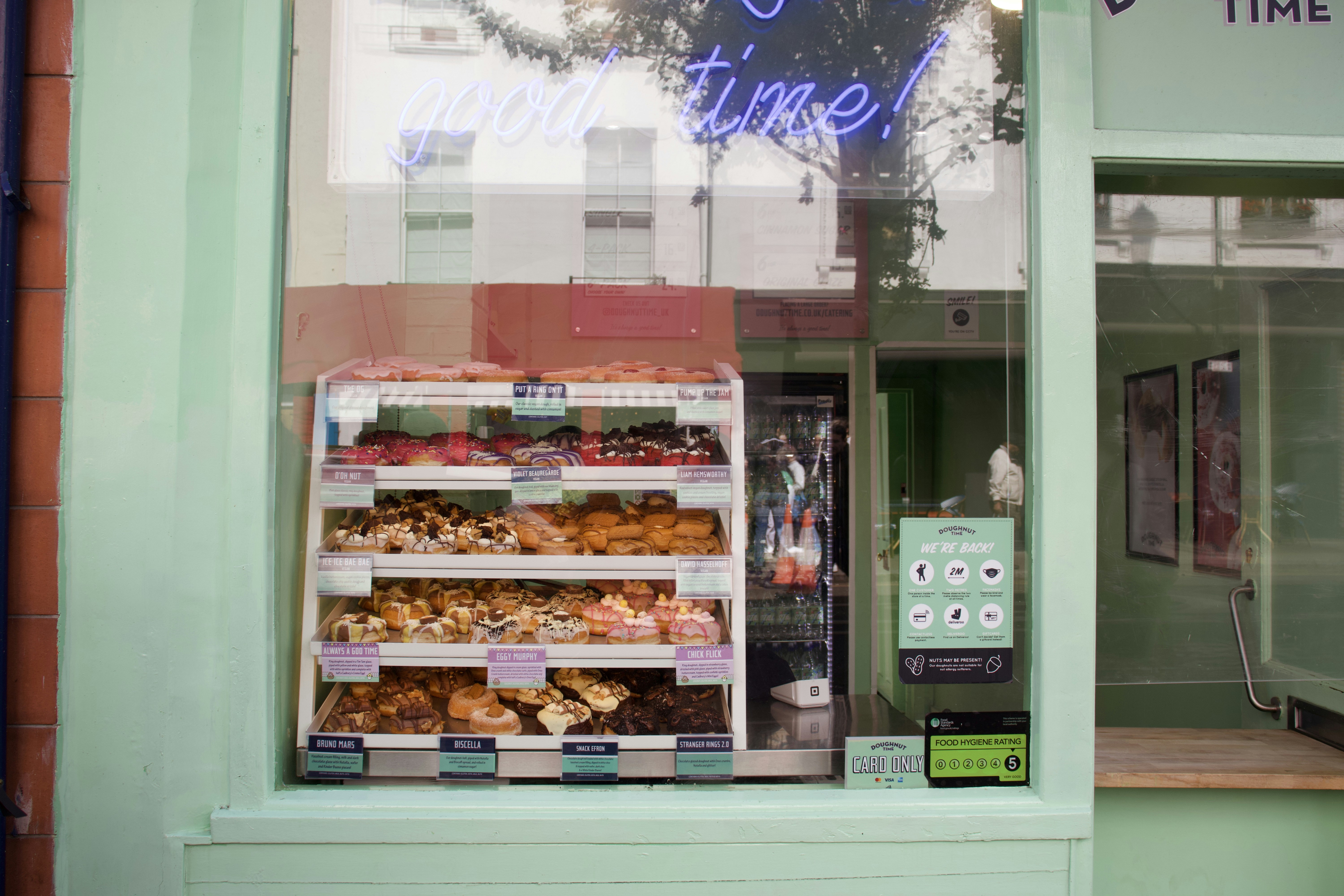 a store front with a display of donuts and pastries