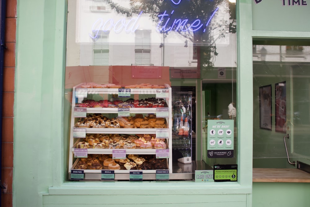 a store front with a display of donuts and pastries
