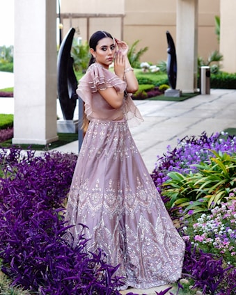 a woman in a long dress standing in a garden