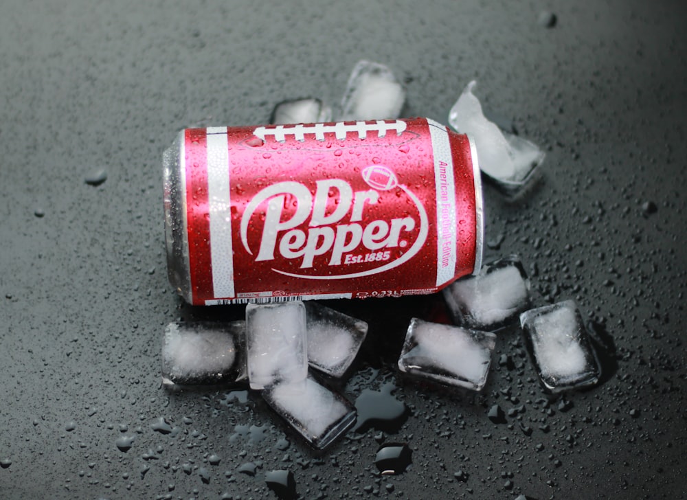 a can of soda sitting on top of ice cubes