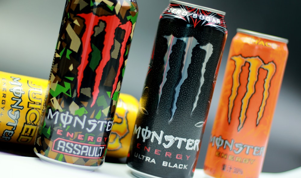 a group of monster energy drinks sitting on top of a table