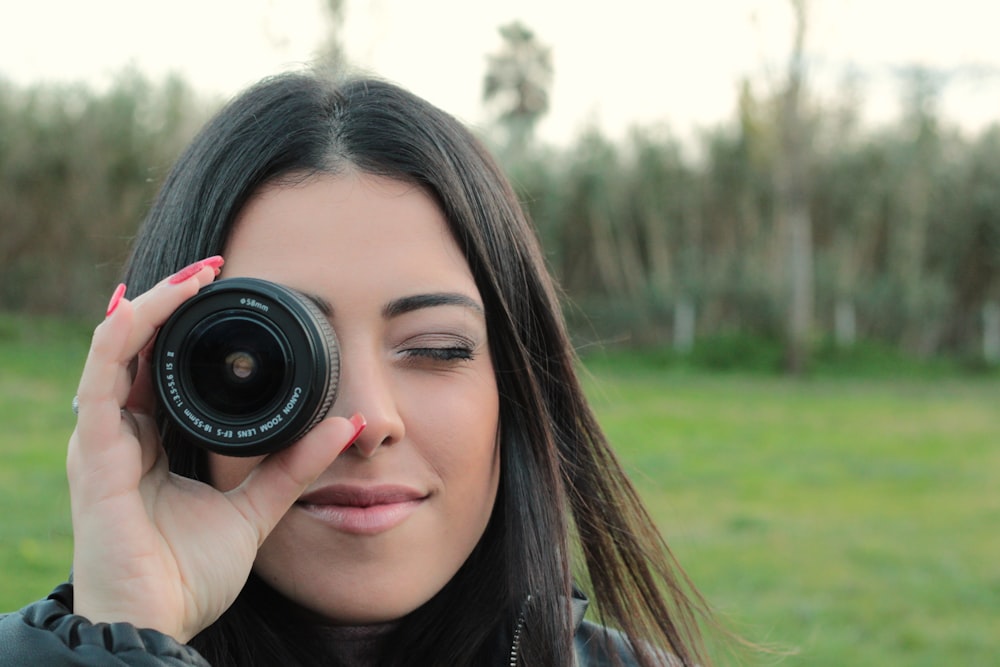 a woman holding a camera up to her face