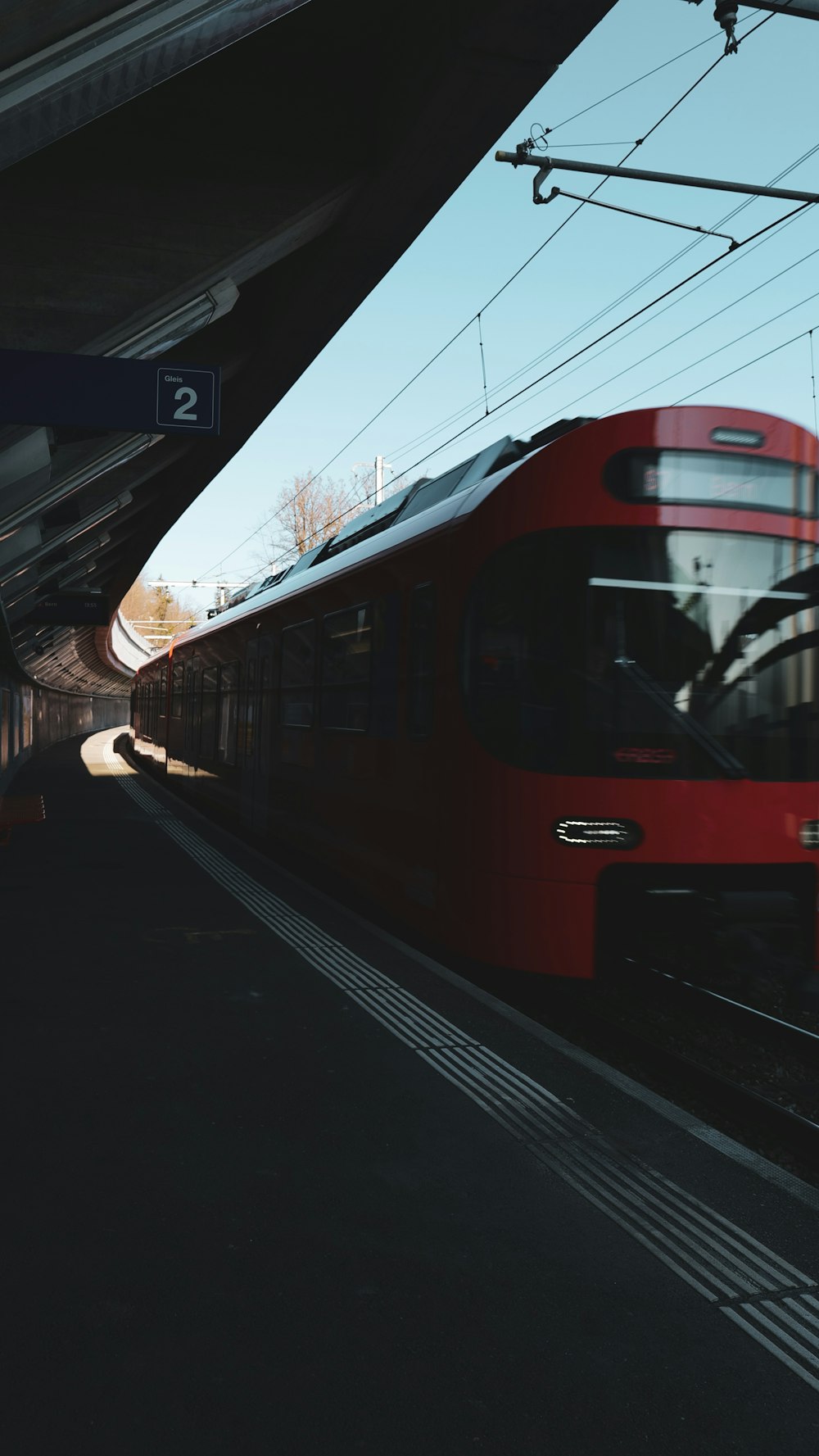 Ein roter Zug fährt in einen Bahnhof ein