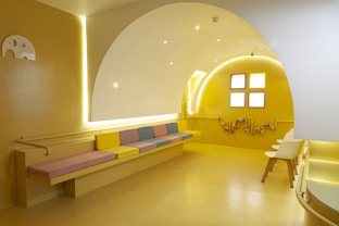 a room with yellow walls and a bench