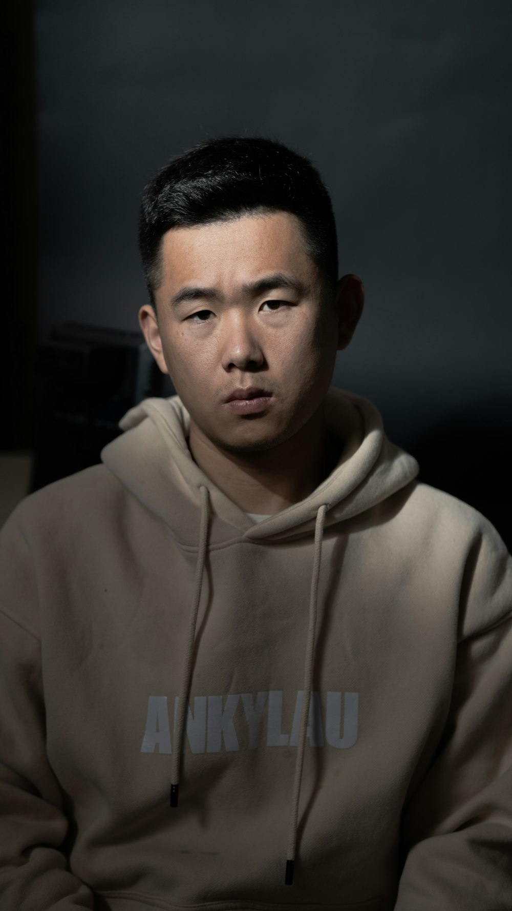 a man in a hoodie is looking at the camera