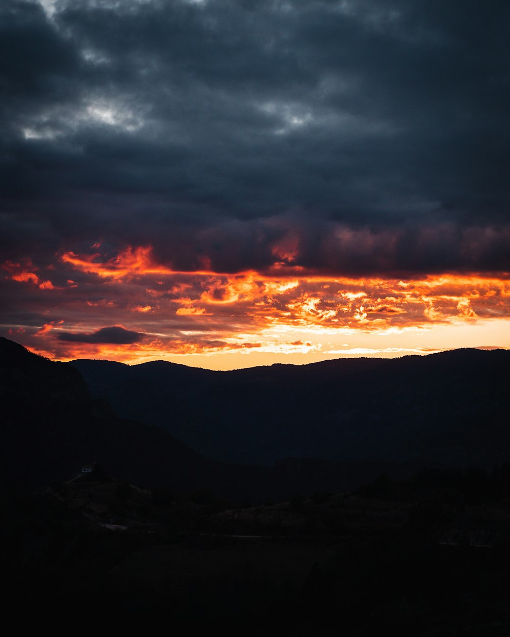 the sun is setting over a mountain range