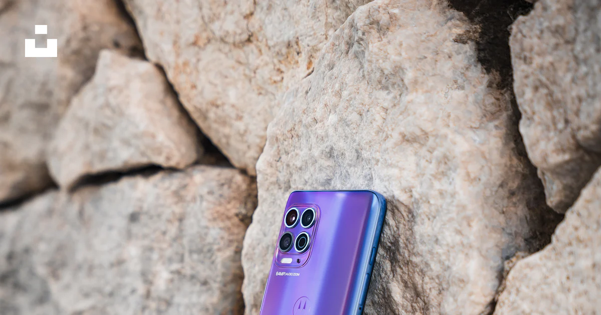 A purple cell phone sitting on top of a rock photo – Free Motorola g100 ...