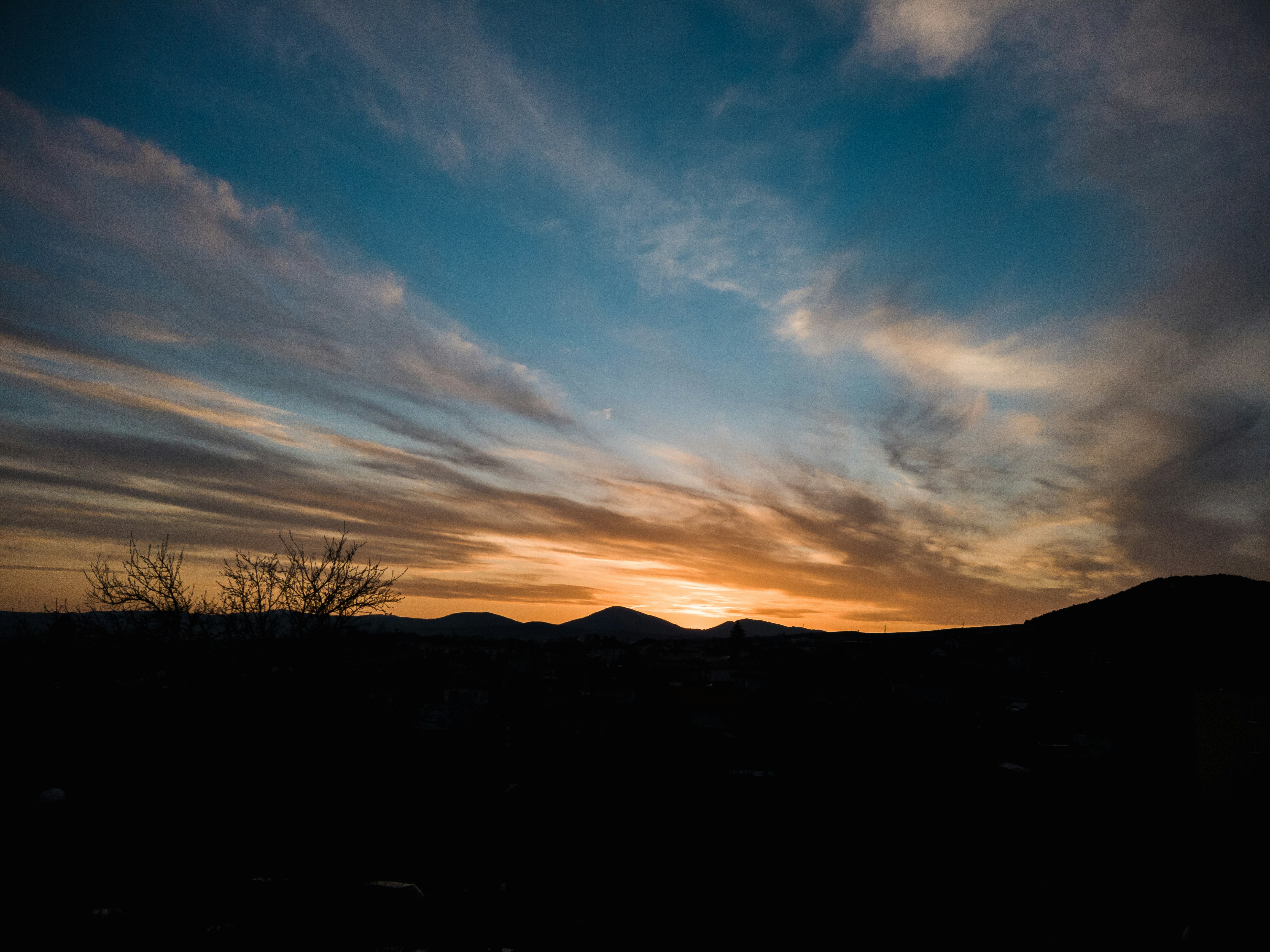 the sun is setting over a mountain range