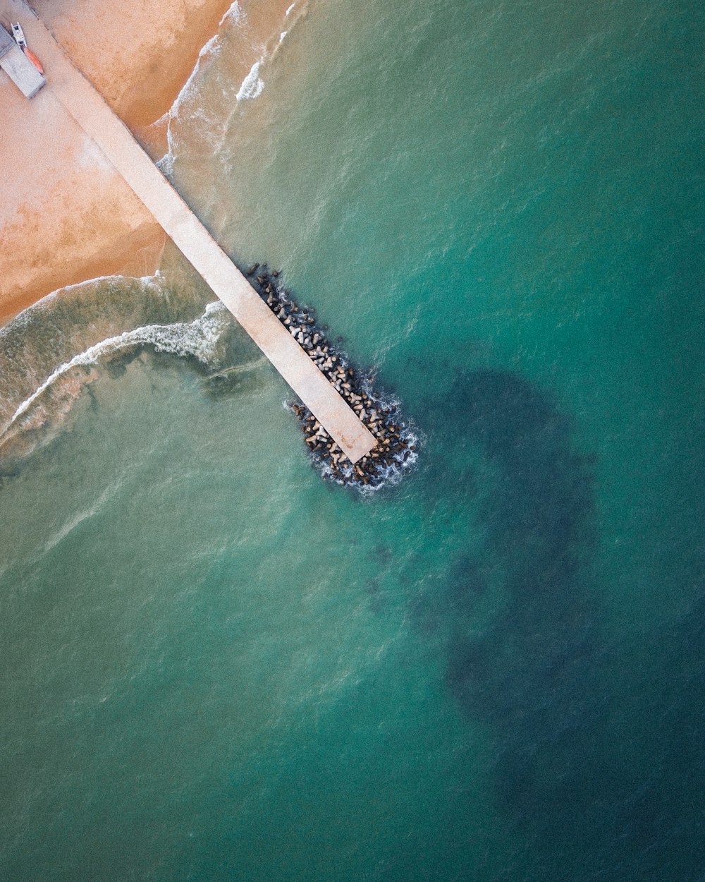 an aerial view of a pier in the ocean