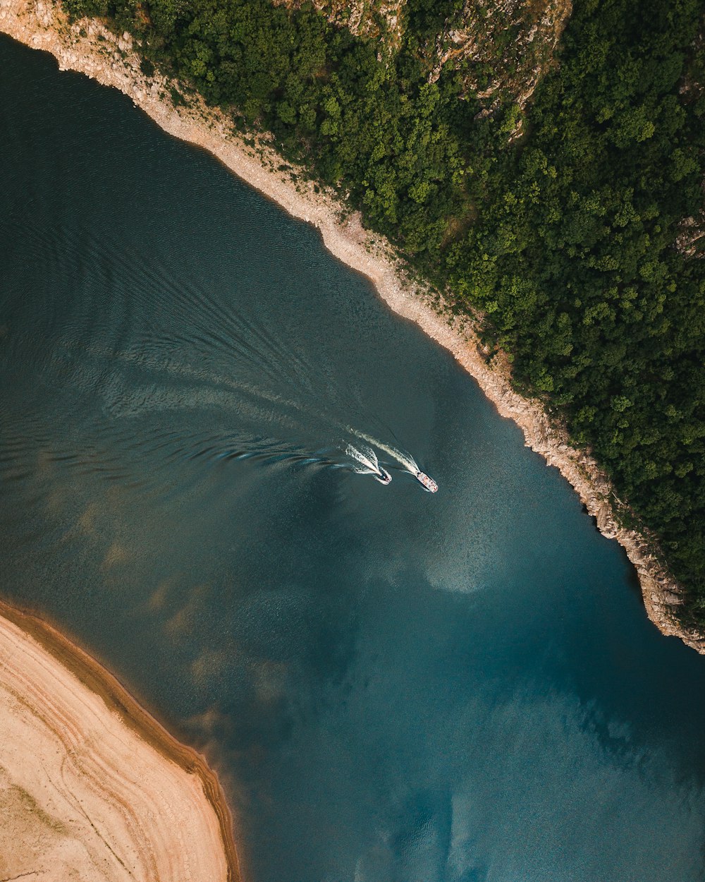 an aerial view of a boat in a body of water