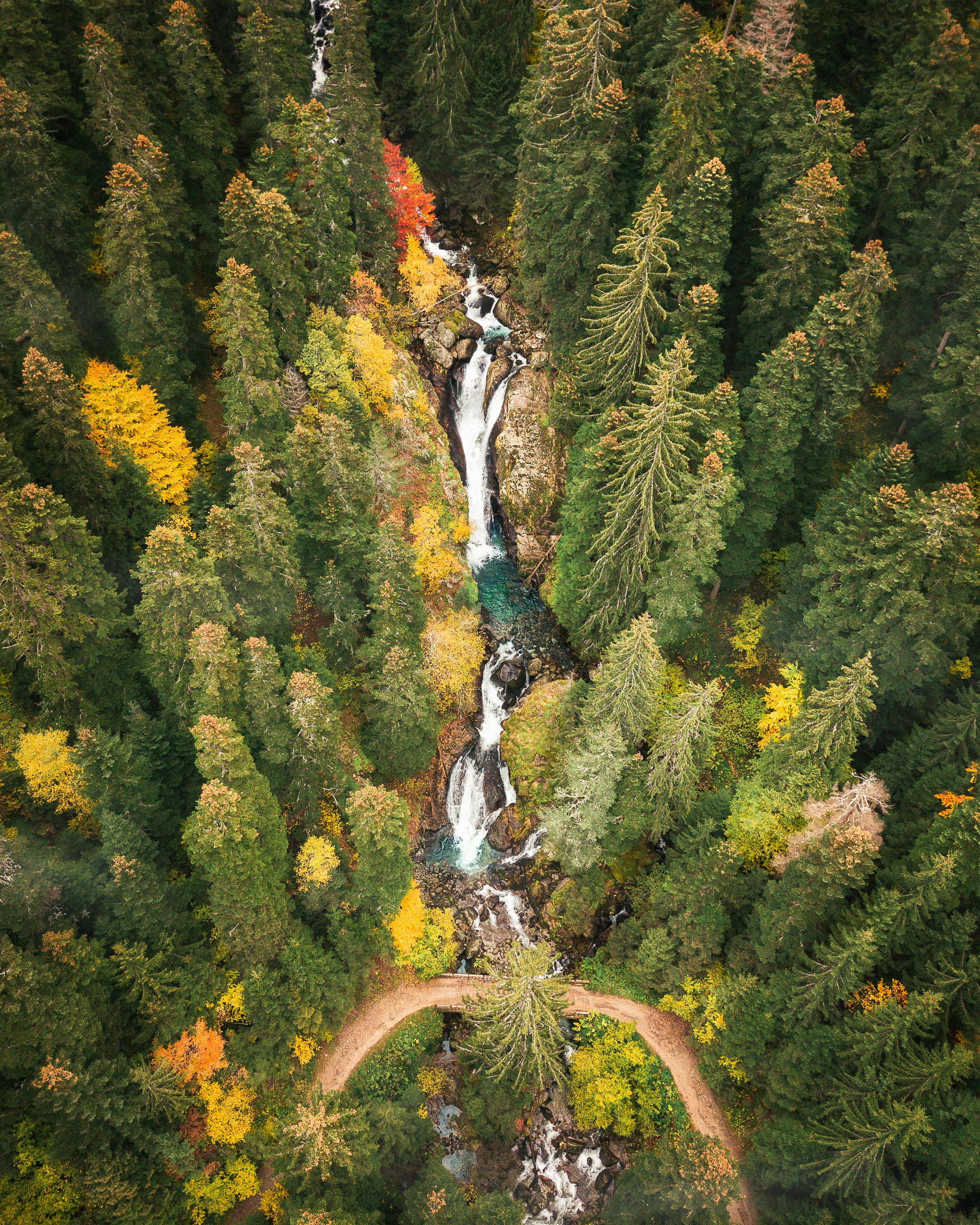 an aerial view of a waterfall surrounded by trees