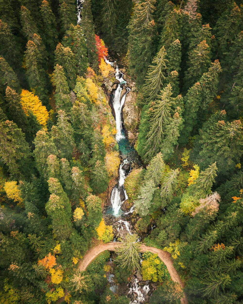 an aerial view of a waterfall surrounded by trees