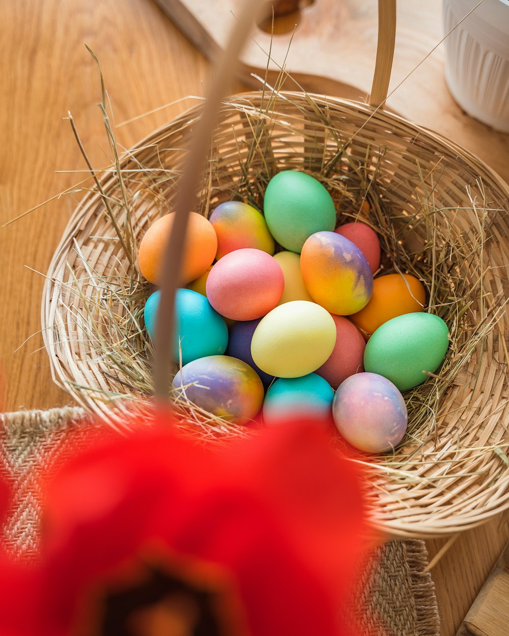 나무 테이블 위에 색깔 계란으로 가득 찬 바구니