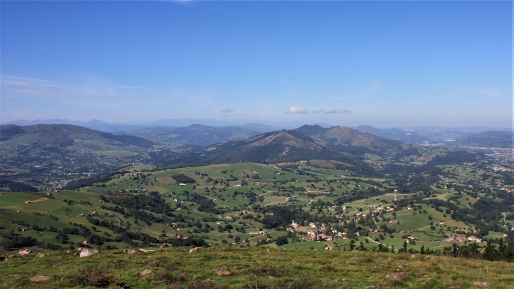 a scenic view of a valley with mountains in the background