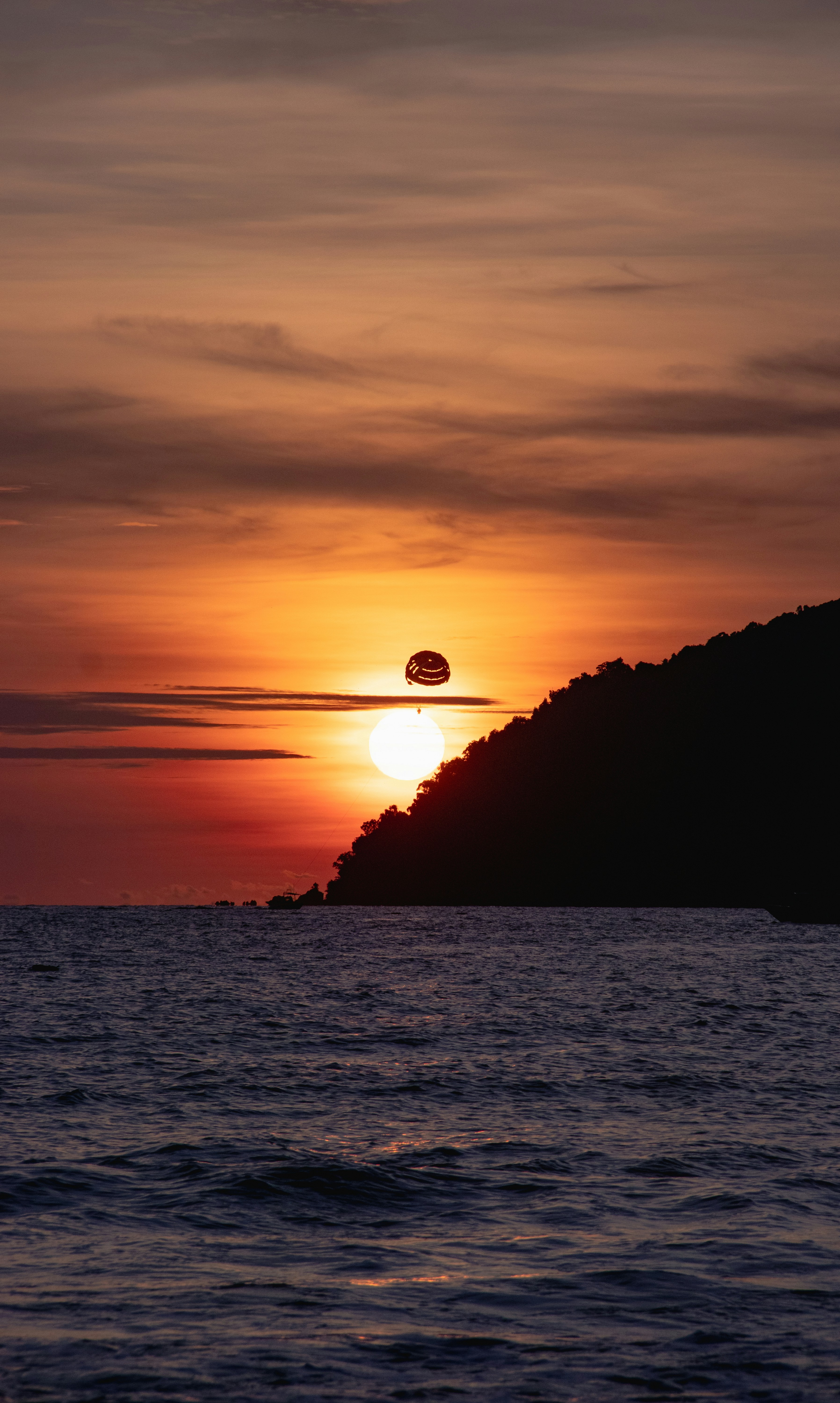 the sun is setting over a small island in the middle of the ocean