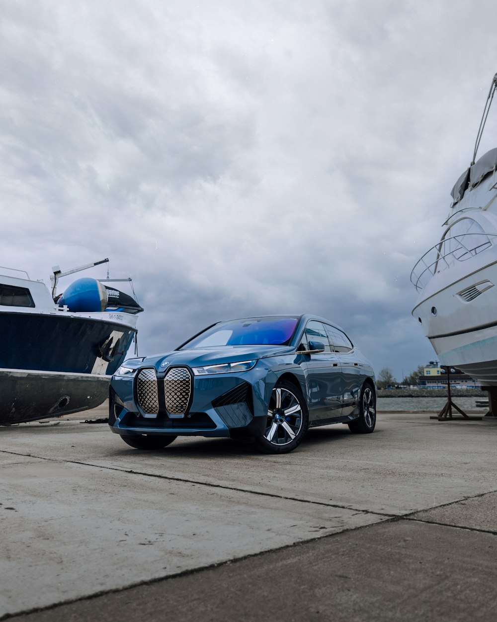 a blue car is parked next to a boat