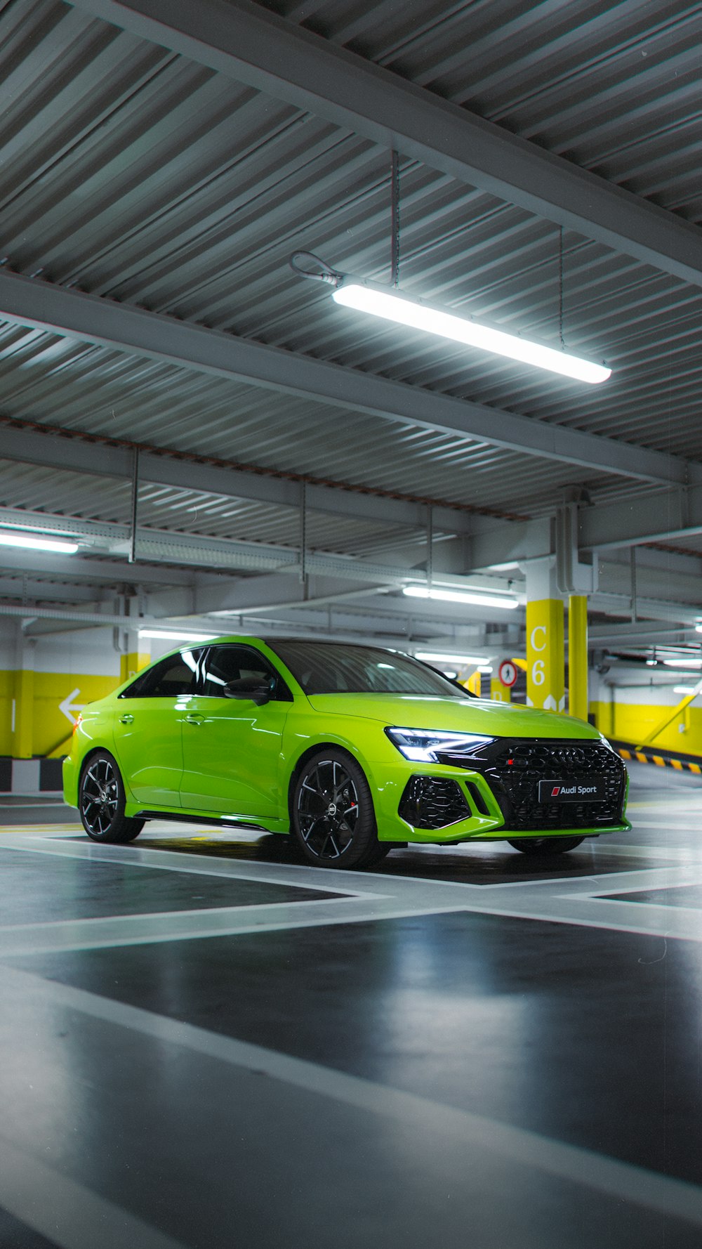 a green car parked in a parking garage