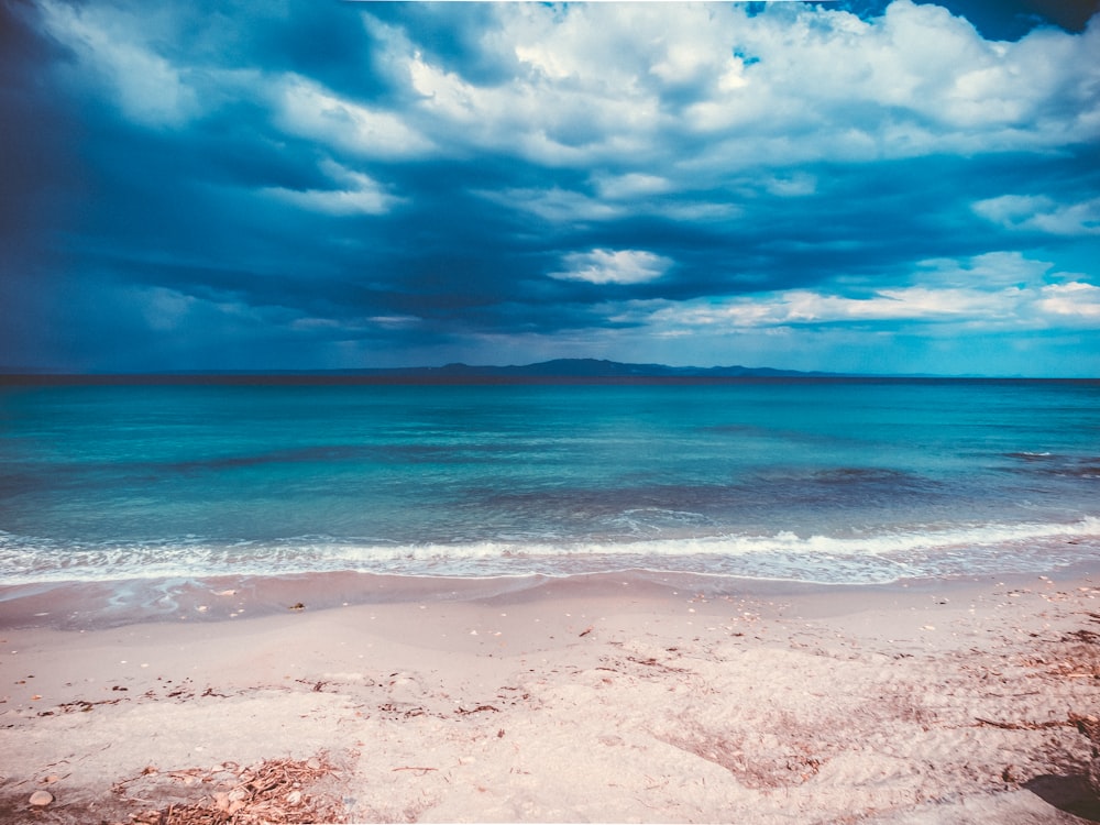 a view of a beach with a cloudy sky