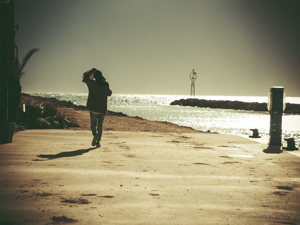 a person walking on a beach next to the ocean