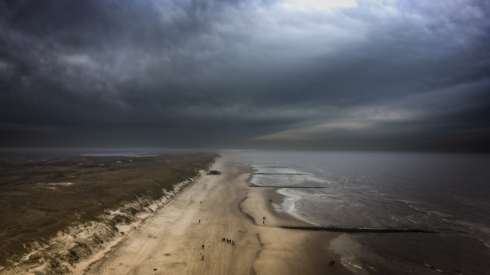 an aerial view of a beach and ocean under a cloudy sky