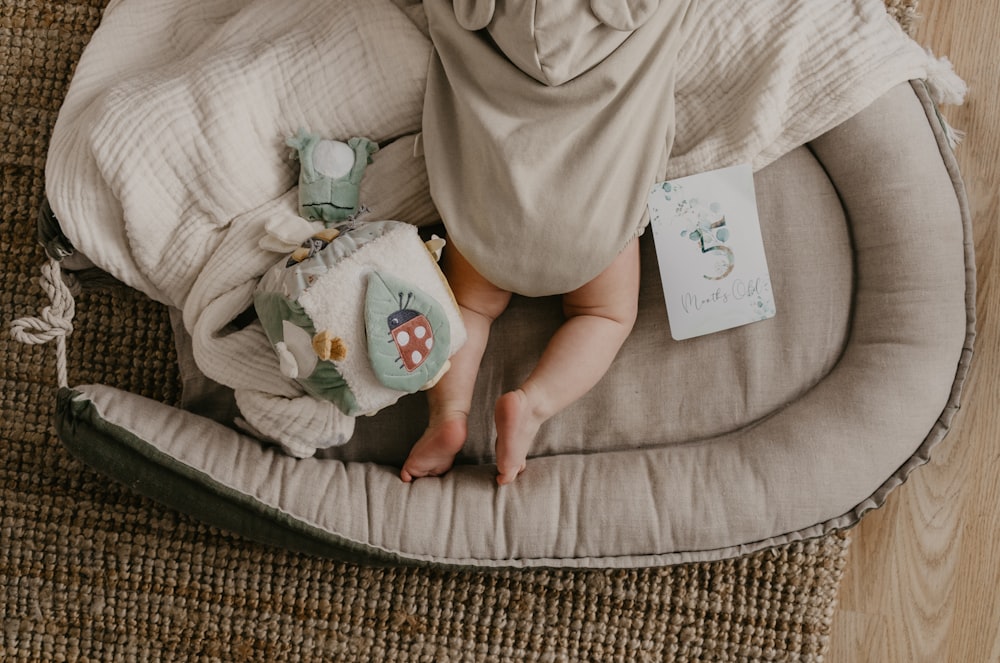 a baby laying on a bed with a stuffed animal