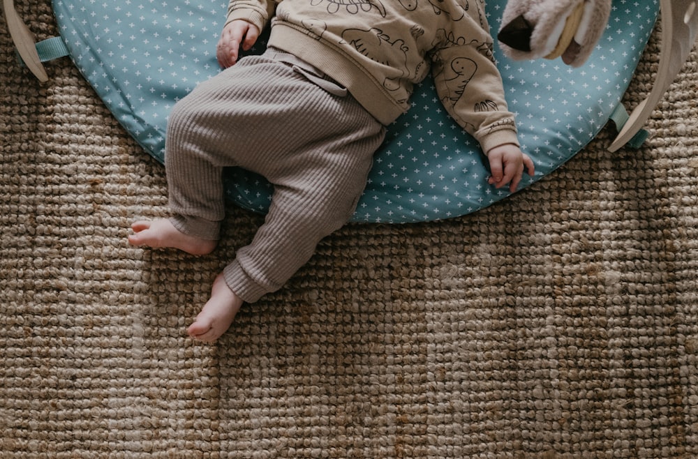 a baby laying on top of a blue pillow