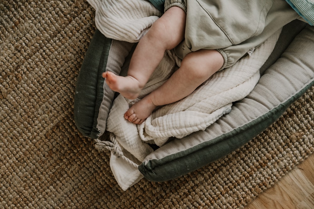 a baby laying on top of a blanket on top of a wooden floor